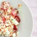 fotografía de la ensalada de legumbres en un plato banco y con mantel rosa claro