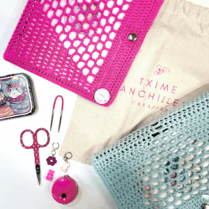 Agendas tejidas en fucsia y verde agua con accesorios de tejido y bolsa de tela con el logotipo Txime La Mariposi.